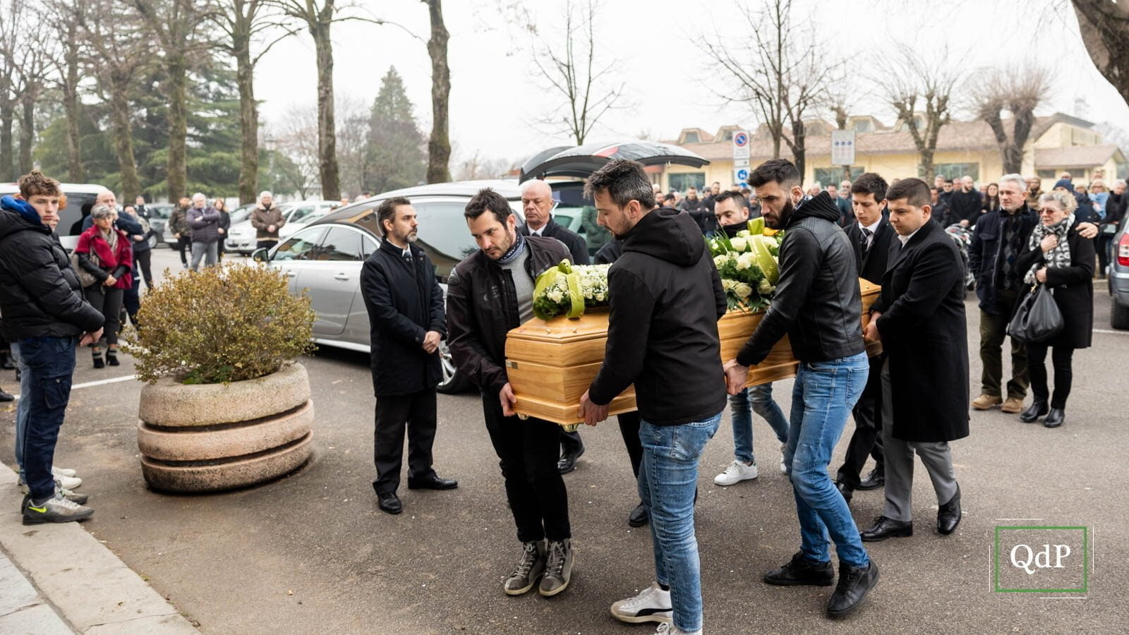 Gli amici che portano la bara all’interno della chiesa